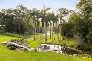 a park with a picnic table and a pond at Latitude 156 - Elevated Luxury Overlooking the Greens in Doonan