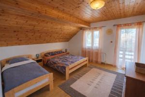 a bedroom with two beds and a wooden ceiling at Orion in Borzont