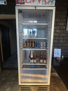 an open refrigerator filled with lots of bottles of beer at Snow Leopard Hostel in Karakol