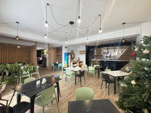 a restaurant with tables and chairs and a christmas tree at winter house GUDAURI in Gudauri