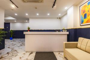 a lobby with a bar and a couch at The PratiQ Neo - Meera Bagh in New Delhi