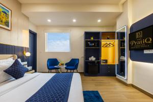 a hotel room with a bed and two chairs at The PratiQ Neo - Meera Bagh in New Delhi +67 photos