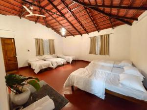 a bedroom with two beds in a room at Hidden Roots Sakleshpur in Hanbalu