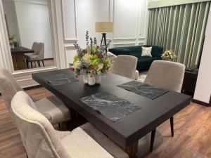 a dining room with a black table and chairs at The Golfside Luxe in Gonapola +13 photos