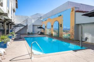 a swimming pool with a mural on the side of a building at DoubleTree by Hilton Campbell - Pruneyard Plaza in Campbell