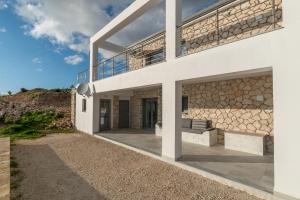 a house on the beach with a balcony at Villa Orizzonte - Ground Floor Apartment with shared pool & amazing view in Keri