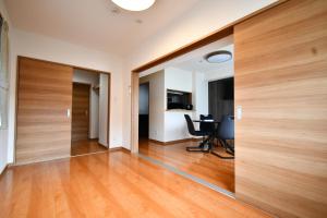 an empty room with wooden doors and a desk at ウエストワン サウス106Hanatebako in Hitoyoshi