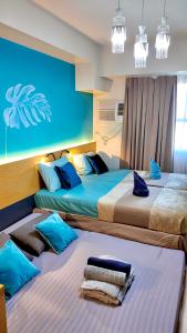 three beds in a room with blue and white at Horizons 101 Cebu- Premium Studio in Cebu City +17 photos