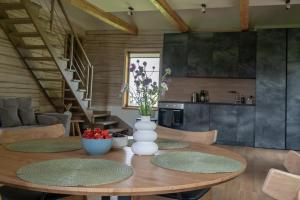 a dining room table with a vase of flowers on it at Panekelpių vienkiemis in Aguriškės +27 photos