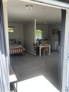 a living room with a table and chairs and a bed at The Cottage in Waikawa in Waikawa +3 photos