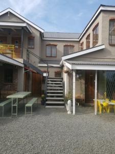 a house with a patio with a table and a bench at By The Way Guesthouse in Clarens