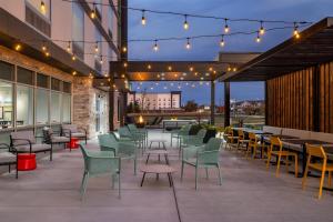a patio with chairs and tables and lights at Home2 Suites By Hilton Muncie in Muncie