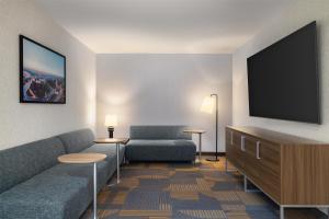 a living room with a couch and a flat screen tv at Home2 Suites By Hilton Muncie in Muncie