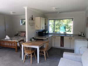 a kitchen and living room with a table and a couch at The Cottage in Waikawa in Waikawa