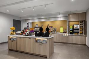 a restaurant with a counter with plates and drinks at Home2 Suites By Hilton Muncie in Muncie +33 photos