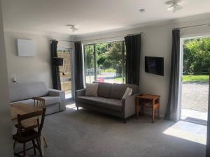 a living room with a couch and a table at The Cottage in Waikawa in Waikawa