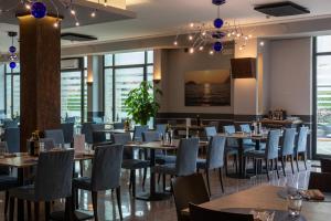 a dining room with tables and chairs and windows at Sole della Franciacorta - Hotel & Restaurant in Capriolo