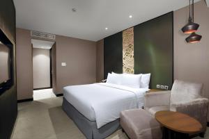 a hotel room with a bed and a couch at Aston Priority Simatupang Hotel and Conference Center in Jakarta +36 photos