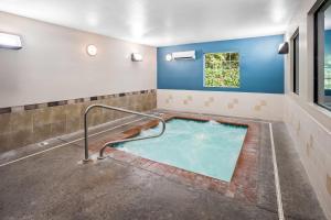 a hot tub in a room with blue walls and a window at Quality Inn Port Orchard in Port Orchard