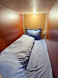 a bed in a small room with a wooden wall at Hostel 405 Sa Pa in Sapa