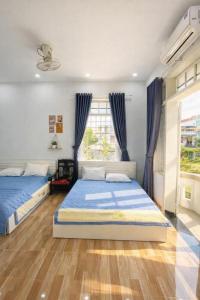 a bedroom with two beds and a window at Nhat Long Homestay in Hue