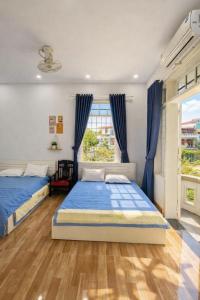 a bedroom with two beds and a window at Nhat Long Homestay in Hue