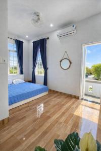 a bedroom with a blue bed and a window at Nhat Long Homestay in Hue