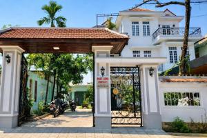 a gate in front of a white house at Nhat Long Homestay in Hue