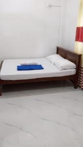 a bed with white sheets and a wooden frame at Villa Rashel in Nikawatawana