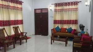 a living room with a couch and chairs and a door at Villa Rashel in Nikawatawana +2 photos