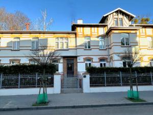 a large house with a fence in front of it at Apartament 100m od morza in Sopot