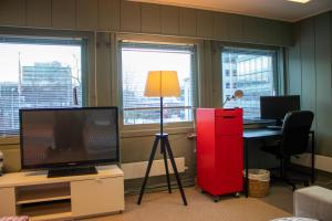an office with a red cabinet and a desk with a television at The Cozy Oslo Stay in Oslo