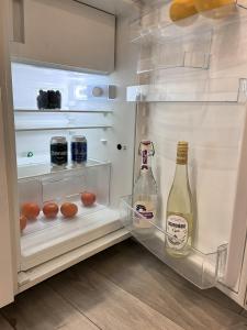 an open refrigerator with two bottles of alcohol in it at Apartament 100m od morza in Sopot