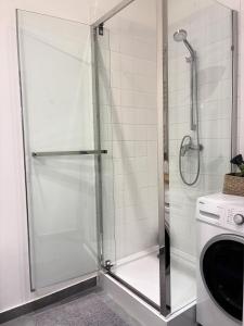 a shower with a glass door in a bathroom at Apartament 100m od morza in Sopot +26 photos