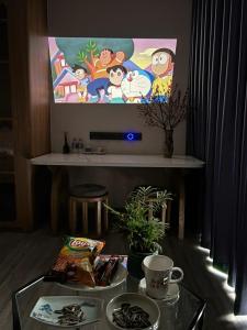 a living room with a tv and a table with food at Măng Homestay in Kim Quan
