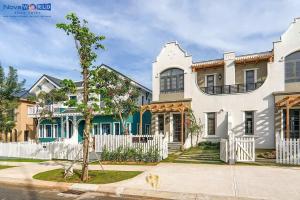 a large white house with a white fence at Sunset Villa - Novaworld Phan Thiết in Bình Tú