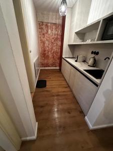 a kitchen with white cabinets and a wooden floor at Residence Polonia - LAST available dates in Karlovy Vary