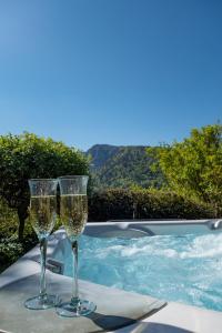 two glasses of champagne sitting on a table next to a swimming pool at Tiny de l'Aigle in Villeret