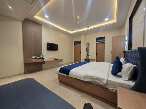a bedroom with a large bed and a tv at Hotel Shree Karni Palace in Kishangarh