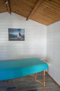 a blue bench in a room with a picture on the wall at Tiny de l'Aigle in Villeret