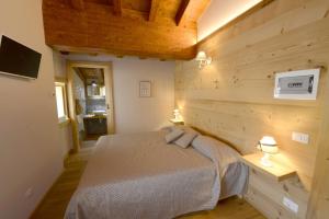 a bedroom with a bed and a wooden wall at Il Faita in Passo del Tonale