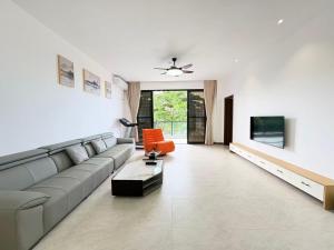 a living room with a couch and a tv at Xiaos Henderson Hotel in Lungga