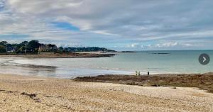 two people standing on a beach near the water at Kercabellec entre mer et marais in Mesquer