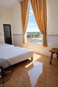 a bedroom with a bed and a large window at Tam Ky XO Hotel in Tam Kỳ +29 photos