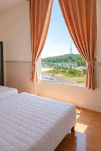 a bedroom with a bed and a window with a view at Tam Ky XO Hotel in Tam Kỳ