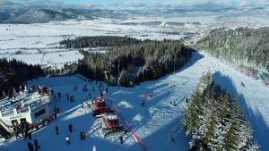 a group of people on a ski slope in the snow at Lumena - Kingsize Beds, ultracentral, 80mp in Topliţa