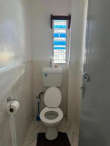 a small bathroom with a toilet and a window at YaNuYaNu Appartment Nabua in Suva