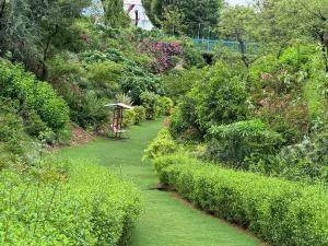 a garden with green grass and a path with an umbrella at Sunrise Dreamworld Resort in Chonp
