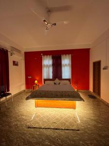 a bedroom with a bed in a red room at Jorhat HideAway in Jorhat