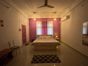 a bedroom with a bed and a ceiling fan at Jorhat HideAway in Jorhat